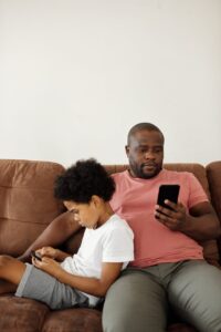 father and son using smartphones